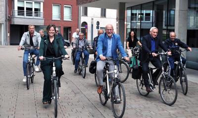 Gedeputeerde Moens op fiets